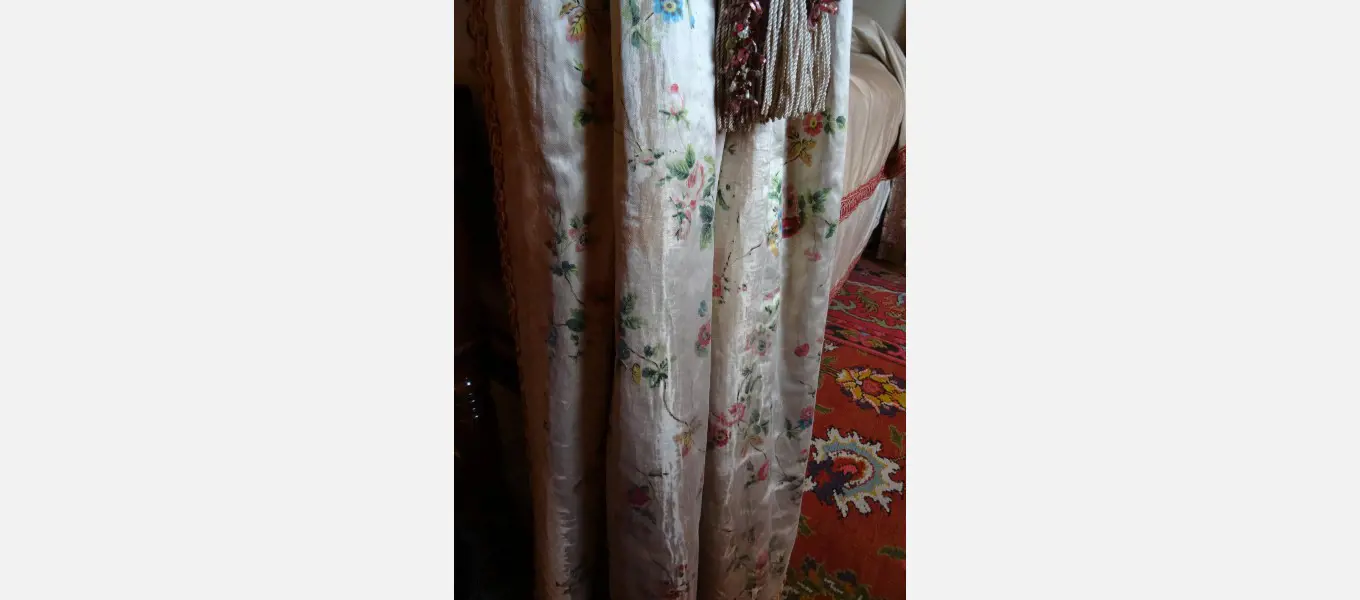 The bed hangings that Meta Gaskell suggested she and her mother should wear down to dinner. 